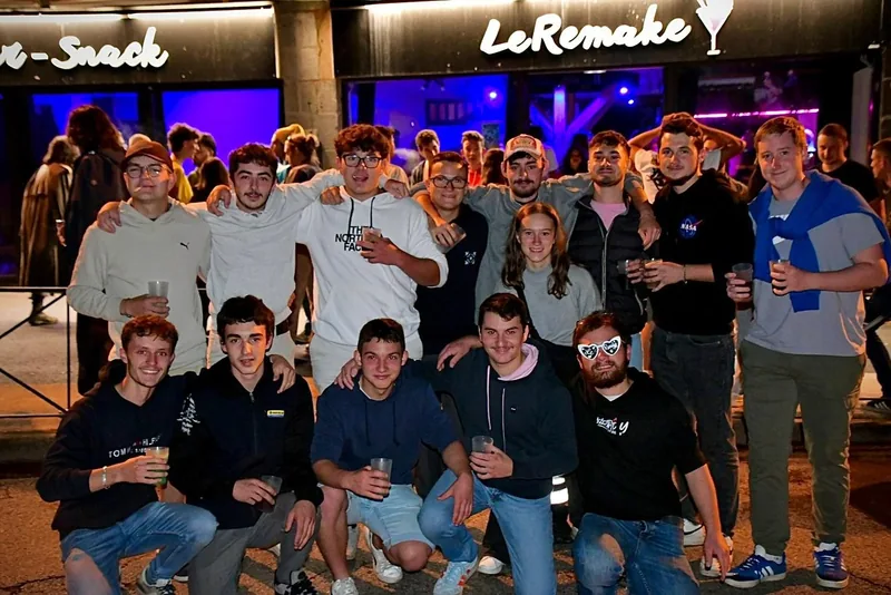 Façade de nuit, clients devant le bar