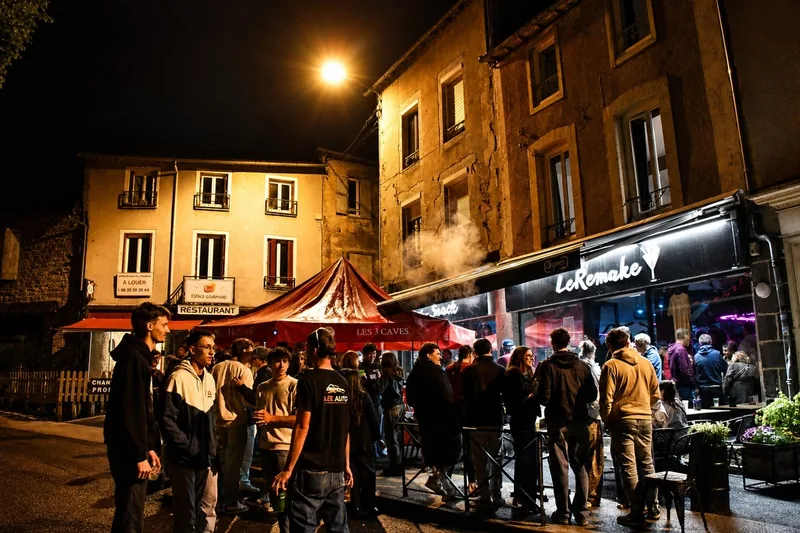 Façade de nuit, enseigne allumée, terrasse pleine